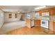 Kitchen with wood cabinets, white appliances, and a breakfast bar at 207 Christy Ln, Locust, NC 28097