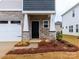 Inviting front entry with a covered porch, stone accents, and a black front door at 471 Olympia Way # 101, York, SC 29745