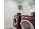 Laundry room with red front-loading washer and dryer and wire shelving at 8306 Hibiscus Ln, Fort Mill, SC 29707