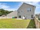 Fenced backyard with a concrete patio, green lawn, and visible neighboring houses at 1051 Barnette Farm Ln, Monroe, NC 28110