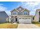 Charming two-story home with a welcoming front porch and attached two-car garage at 1051 Barnette Farm Ln, Monroe, NC 28110