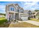 Charming two-story home with a front porch, landscaping, and an attached garage at 1051 Barnette Farm Ln, Monroe, NC 28110