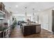 Open concept kitchen with island, stainless steel appliances, and dark wood cabinets at 117 Fairfield Dr, Troutman, NC 28166