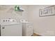 Laundry room with Whirlpool washer and dryer units and storage shelf at 12157 Lady Bell Dr, Charlotte, NC 28278