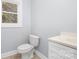 Clean bathroom includes a toilet, sink, and white vanity at 12491 Oak Grove Rd, Stanfield, NC 28163