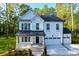 Charming two-story farmhouse with white siding, dark metal roof, and a two-car garage at 13019 Arnold Palmer Cir # 832, Lancaster, SC 29720