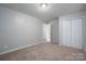 Empty bedroom with tan carpet, gray walls, and white closet doors at 121 Pam Dr, Gastonia, NC 28056