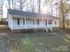 Front exterior of a one-story home with a covered porch, white siding, and brick foundation at 121 Pam Dr, Gastonia, NC 28056