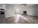 Living room with brick fireplace, ceiling fan, and wood-look flooring, open to the kitchen at 121 Pam Dr, Gastonia, NC 28056