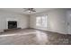Living area with fireplace, ceiling fan, abundant natural light, and wood-look flooring at 121 Pam Dr, Gastonia, NC 28056