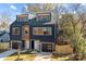 Modern two-story duplex with blue and brown siding, attached garages, and a fenced yard at 137 S Smallwood Pl, Charlotte, NC 28208