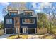 Modern two-story duplex with blue and brown siding, attached garages, and a fenced yard at 137 S Smallwood Pl, Charlotte, NC 28208