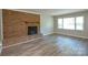 Living room with brick fireplace, wood-look flooring, and large window at 3201 Oscar Dr, Matthews, NC 28105