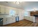 White kitchen cabinets and quartz countertops open to the living room at 1254 Huckleberry Dr, Lincolnton, NC 28092