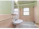 Small bathroom with pink tile and a pedestal sink at 306 E Herman St, Newton, NC 28658