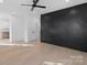 Main bedroom featuring hardwood floors and a dramatic accent wall at 97 Lowe Nw Ave, Concord, NC 28027