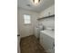 The laundry room features white appliances, storage shelving, and tile flooring at 147 Ranlo Ave, Gastonia, NC 28054