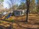 Backyard view of home with playset and wooded area at 5040 Spicewood Dr, York, SC 29745