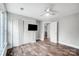 Bedroom with wood-look flooring, white closet doors, ceiling fan, and a TV mounted at 520 Beacon Knoll Ln, Fort Mill, SC 29708