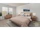 Virtually staged bedroom with light beige bedding and wood furniture at 213 Alden Ct, Shelby, NC 28152