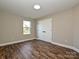 Empty bedroom with wood-look flooring, neutral walls, and white double doors at 409 Mint St, Rock Hill, SC 29730