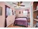 Pink bedroom with purple bedding, ceiling fan, and built-in shelving at 45 Sunderland Rd, Concord, NC 28027