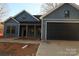 Newly constructed home featuring blue siding, a black garage door, and a covered porch at 635 E Ridge Rd, Salisbury, NC 28144