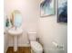 Half bathroom with a pedestal sink, toilet, and wood-style flooring at 110 Windstone Common Ln, Mooresville, NC 28117