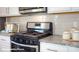 Close-up of the kitchen's stainless steel stove, granite countertop, and white cabinets at 110 Windstone Common Ln, Mooresville, NC 28117