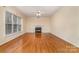 Living room with gleaming hardwood floors, a cozy fireplace, and ample natural light at 11005 Chilcomb Ct, Charlotte, NC 28262