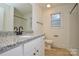 Bathroom with granite countertop, white vanity, and updated fixtures at 412 Lytton St, Troutman, NC 28166