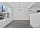 Simple dining room with gray vinyl flooring and a chandelier at 938 Grassy Patch Ln, Charlotte, NC 28216