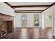 Bright living room with large windows, exposed beams, and a brick fireplace at 14008 Creekside Dr, Matthews, NC 28105