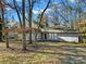 Gray house with mature trees, driveway, and a yard at 6613 Montezuma Trl, Charlotte, NC 28227