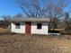 Small white outbuilding with a red door and two windows at 835 Baxley Pond Rd, Kershaw, SC 29067