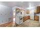 Bright kitchen with wood cabinets, white appliances, and tiled floor at 122 Baldwin Ave, Kannapolis, NC 28083