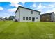 Rear view of a two story home with white siding and large grassy yard at 3050 Swallowtail Ln, Kannapolis, NC 28083