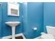 Small powder room with pedestal sink and blue walls at 3505 Savannah Hills Dr, Matthews, NC 28105