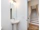 Clean bathroom with pedestal sink and view of stairs at 7022 Impulse Ct, Charlotte, NC 28205
