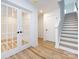 Bright entryway with hardwood floors, double French doors, and staircase at 7022 Impulse Ct, Charlotte, NC 28205