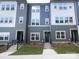 Three-story townhome with gray siding and multiple windows at 7022 Impulse Ct, Charlotte, NC 28205