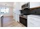 Modern kitchen with stainless steel appliances and dark tile backsplash at 7022 Impulse Ct, Charlotte, NC 28205