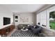 Living room with gray sofas and a geometric patterned rug, featuring abundant natural light at 7932 Cedarsmith Ct, Charlotte, NC 28217