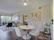 Open concept dining area with white table and chairs, near the living room at 224 N Poplar St # 19, Charlotte, NC 28202