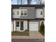 Two-story townhome with gray siding, two-car garage, and landscaping at 3030 Hutton Gardens Ln, Charlotte, NC 28269