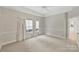 Spacious bedroom with neutral walls, carpet, and access to a bathroom at 6415 Outer Bridge Ln, Charlotte, NC 28270