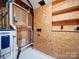 Unfinished basement laundry area with water heater and shelving at 7800 Highbanks Ct, Charlotte, NC 28212