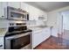 Bright kitchen features stainless steel appliances and white cabinets at 7800 Highbanks Ct, Charlotte, NC 28212