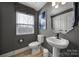 Stylish powder room with pedestal sink and gray walls at 2219 Aria Park Dr, Charlotte, NC 28262