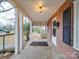 Covered front porch with brick columns and entry door at 1506 Coker Ave, Charlotte, NC 28208